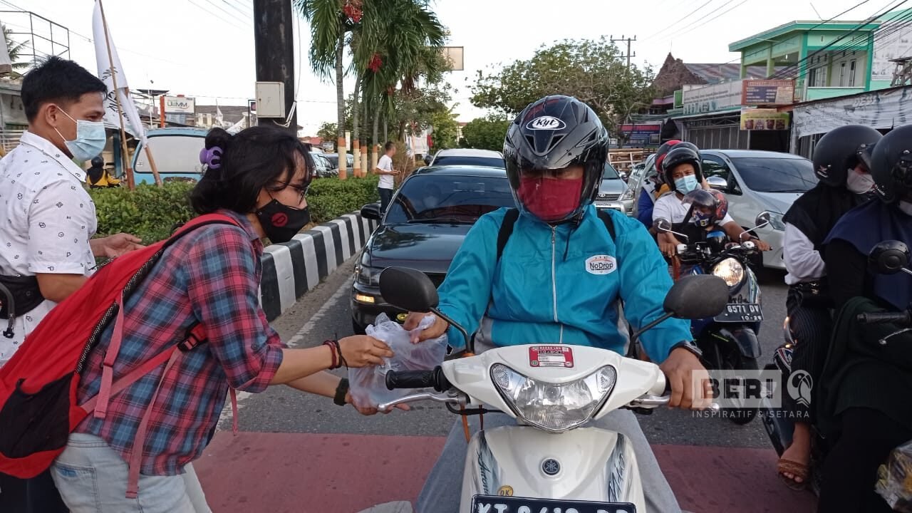 Koordinartor Aksi, Fitri Wahyuningsih membagikan takjil untuk berbuka puasa kepada pengguna jalan di Simpang 3 Plaza Taman, Jalan MH Thamrin, Bontang Baru, Bontang Utara, Senin (3/5/2021) pukul 16.30 Wita. (Doc. Istimewa)